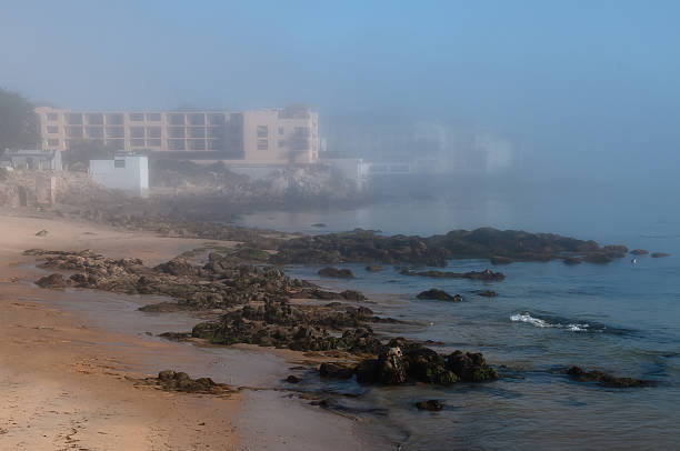 nebel versteckt cannery reihe mit strand im vordergrund, horizontal - monterey california monterey county cannery row stock-fotos und bilder