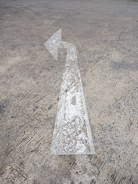 istock Arrow symbol on a black asphalt road surface 584788858