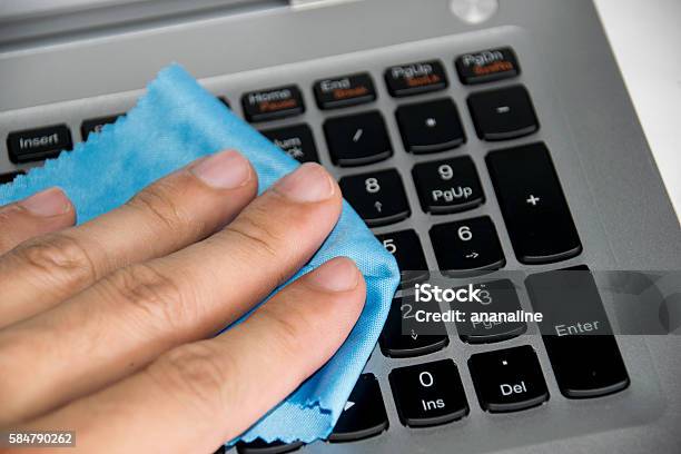 Close Up Holding Blue Wipes To Clean On Keyboard Laptop Stock Photo - Download Image Now