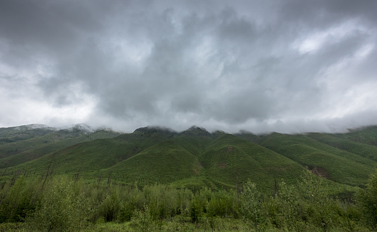 Thick Rain Clouds Over Green Mountains on a rainy summer day