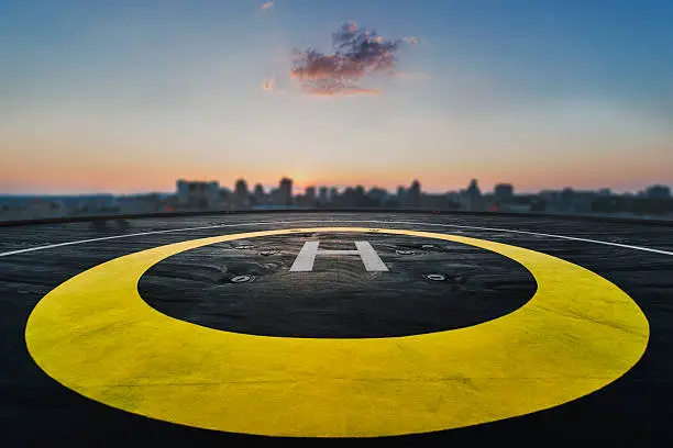 Helipad on the roof of a skyscraper after raining with cityscape view and sunset