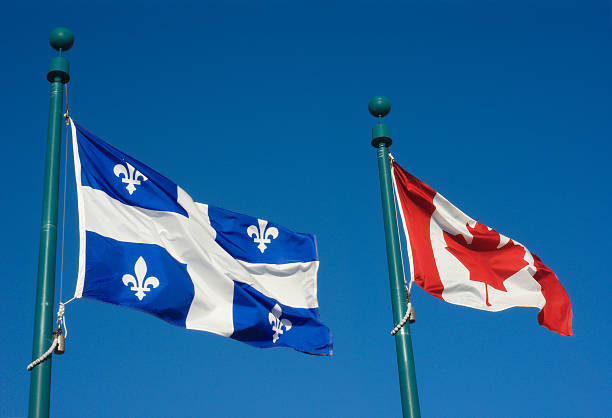 istock Quebec and Canada flags fluttering in the wind  blue sky 584857964
