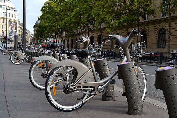 Paris, France - July 11, 2023: Rental bikes in the cityscape of Paris. In the background the tower of Montparnasse.