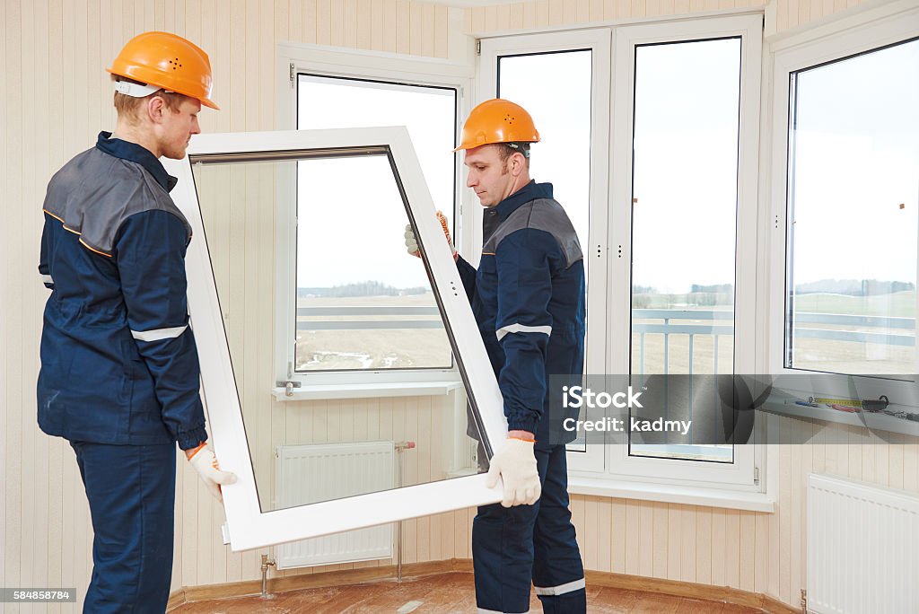 windows installation workers two windows installation workers installing double-glass pane Window Stock Photo