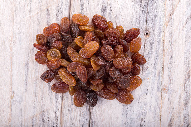 istock dried grapes raisins on white wood background.top view 584859204