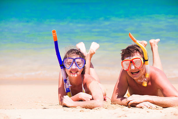 istock couple having lying on summer beach sand with snorkel equipment 584859224