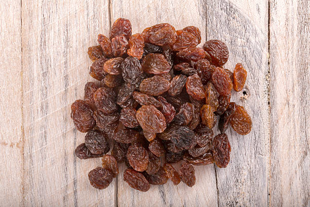istock dried grapes raisins on white wood background.top view 584859930