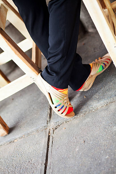 Several pairs of multi-colored rubber flip-flops exhibited in a row, isolated.