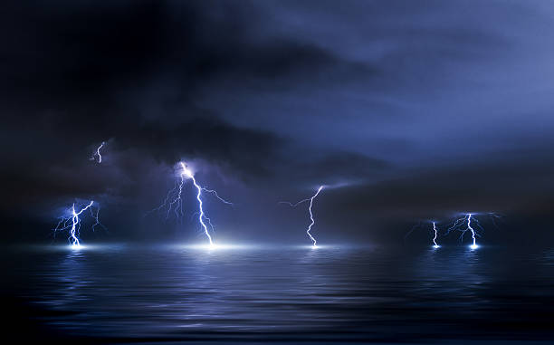 istock Thunderstorm over the sea, lightning beats the water 584862030