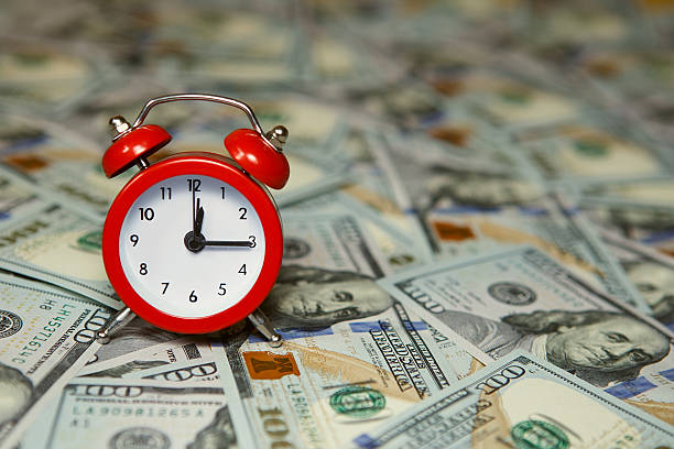 istock Time is money, clocks under american dollars 584862432