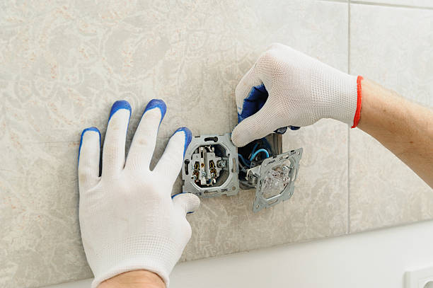 istock Electrician installs electrical outlet. 584864006