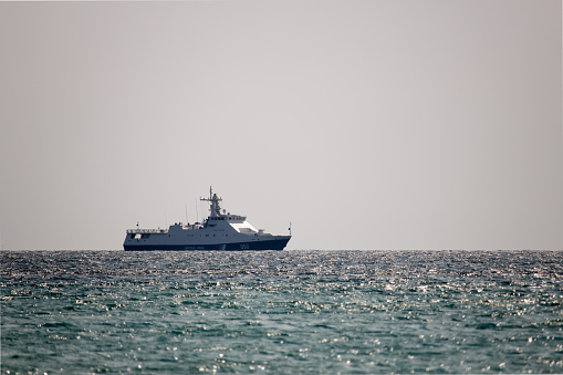 Warship patrolling the coast line during the day