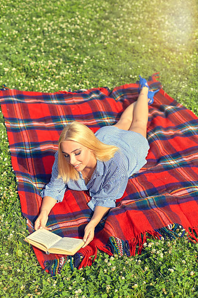 istock Top view woman relaxing outdoors with a book 584864970