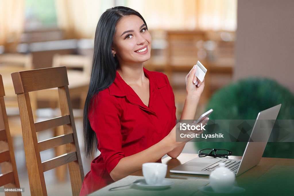 Business woman shopping online Young business woman holding mobile phone and credit card. Woman pays for a purchase with credit card. Purchase online. Shopping online Adult Stock Photo