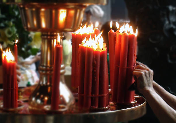 istock Hand Lighting Up Candles In Temple Building 584865312