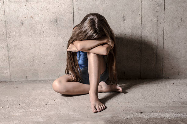 istock Sad and lonely girl beside wall 584865800
