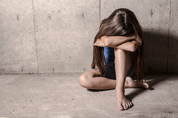 istock Sad and lonely girl beside wall 584865902