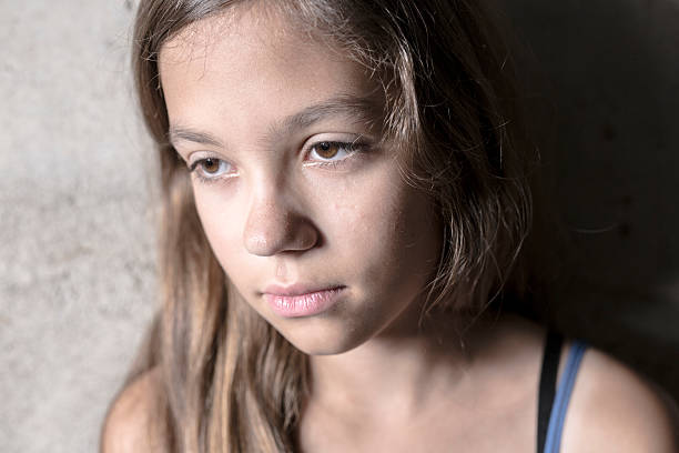 istock Sad and lonely girl beside wall 584866358