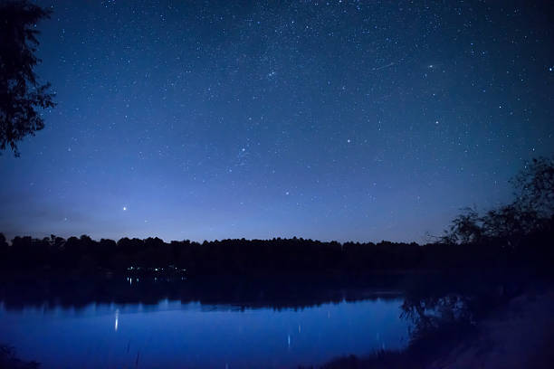 istock Beautiful night sky with many stars on a lake 584867104
