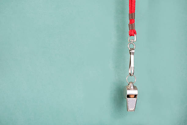 istock Coach's whistle hangs in front of green school chalkboard. 584867542