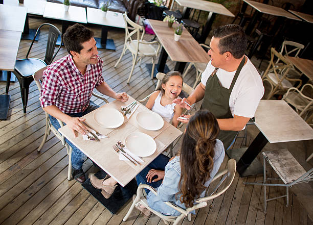 istock Waiter serving family at a restaurant 584870640
