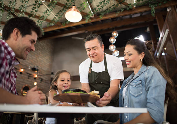 Waiter serving a family at restaurant