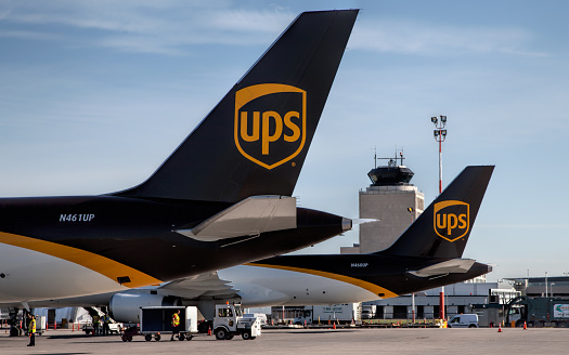 Winnipeg, Canada – July 20, 2016: Two UPS Boeing-757 Cargo Freighters sit on the ramp at Winnipeg James Armstrong Richardson International Airport with the Air Traffic Control Tower in the background