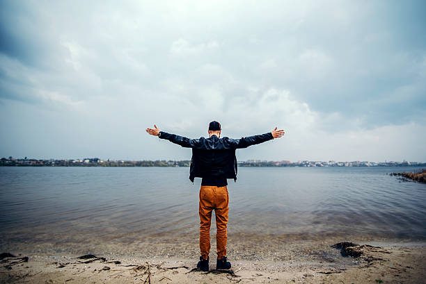 istock Back view of man with lake on background 584872710