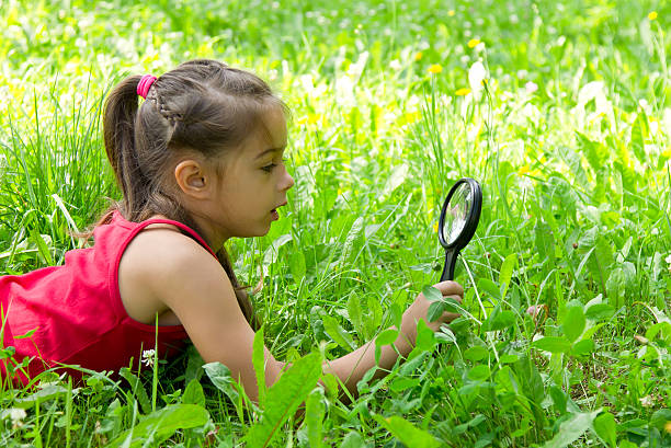 istock Little girl exploring nature with a magnifying glass 584872746
