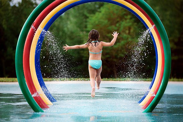 istock Girl running through splash pad 584872784