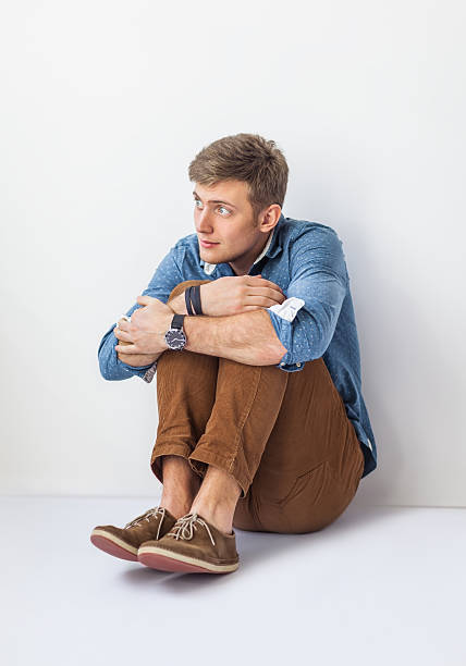 istock Funny scared man sitting on the floor in studio 584873468