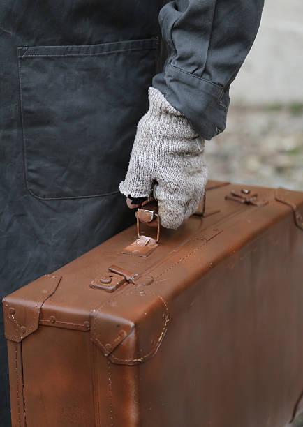 istock immigrant with old leather suitcase and broken gloves 584876124
