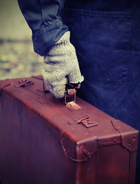 istock poor person with the old worn leather suitcase 584876780