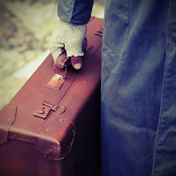 istock poor traveler with old worn leather suitcase 584876852