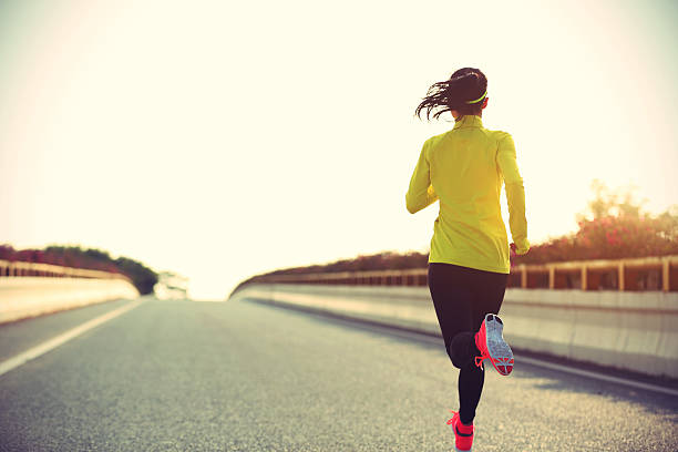 istock young woman runner running on city bridge road 584878546