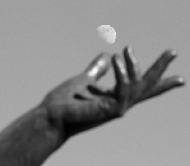 istock hand of statue trying to catch the moon 584879222