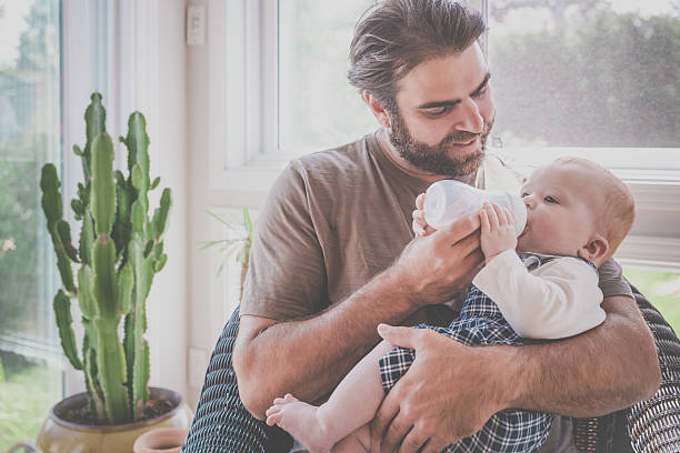 istock Modern Dad Feeding his Baby Boy with Milk Bottle 584879598