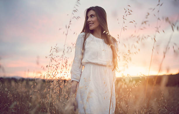 Genuine Glow Portrait of a beautiful caucasian woman at sunset. sundress stock pictures, royalty-free photos & images