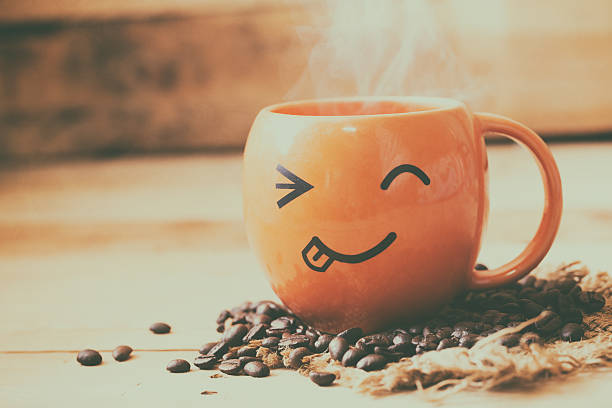 istock smile face hot coffee cup with bean on wood background. 584883698