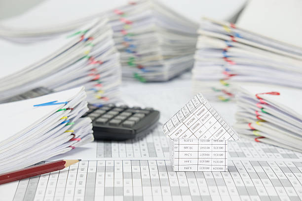 istock House and brown pencil with blur pile paperwork as background 584884972
