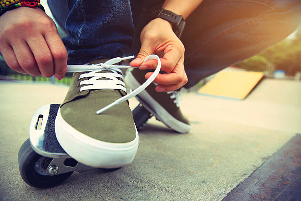 istock freeline skateboarder tying shoelace at skatepark ramp 584885864