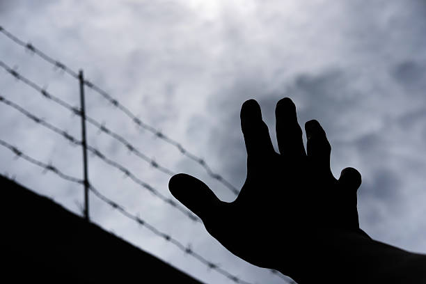 istock Silhouette hand extending to the sky, on gloomy overcast sky 584886392