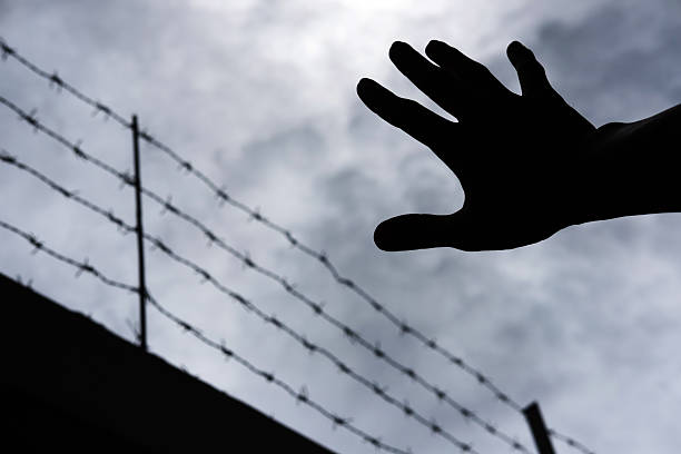istock Silhouette hand extending to the sky, on gloomy overcast sky 584886434