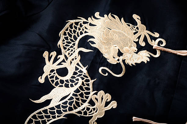 istock Textile gold chinese dragon pattern sewn on black silk 584888260