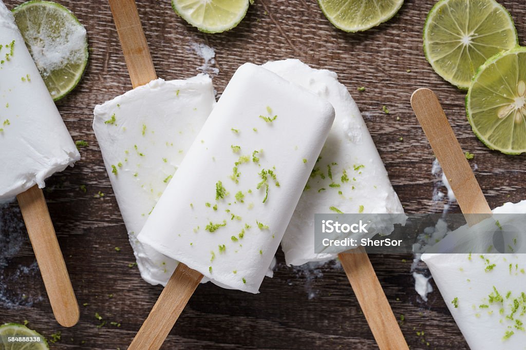 coconut ice pops coconut ice pops ,coconut ice cream bars, with fresh green lime zest on wooden background Flavored Ice Stock Photo