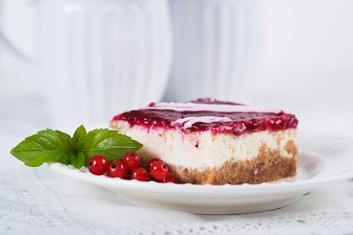 Cake with currant on plate on table on light background
