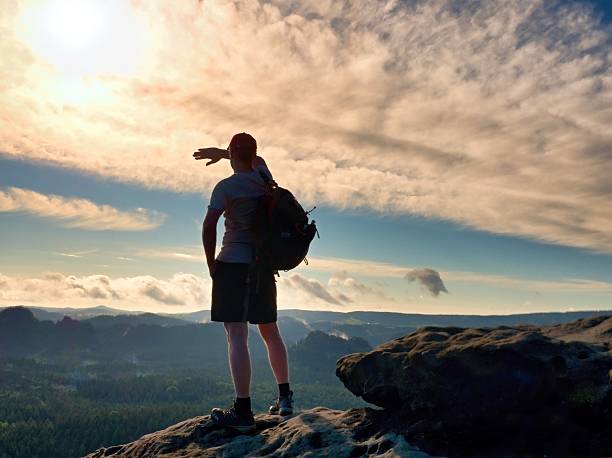 istock Alone tourist  on cliff edge and watching into valley bellow. 584889534