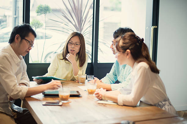 istock Four business people meeting in a cafe 584889670