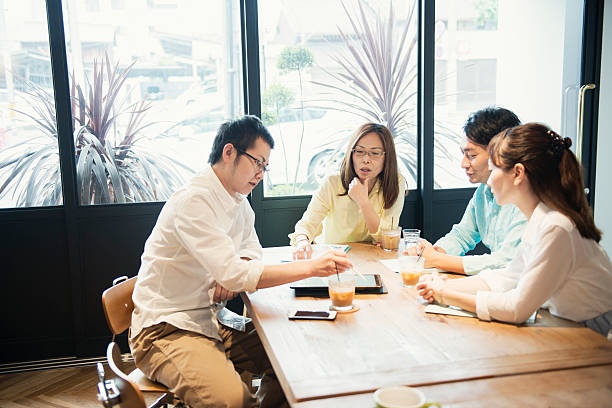 istock Four business people meeting in a cafe 584889704