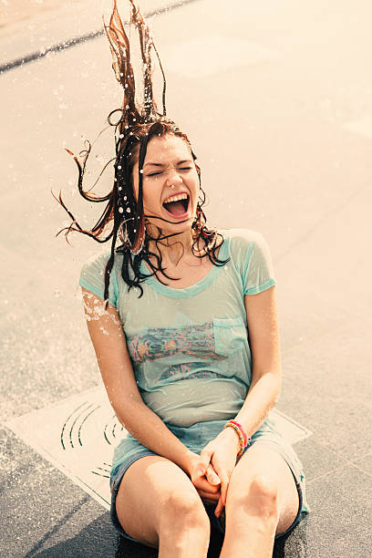 istock Girl having fun in a water fountain 584889988